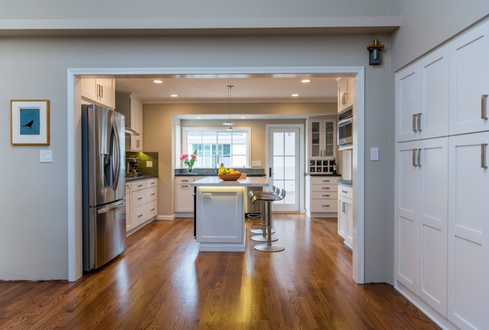 Inspiration for an expansive modern u-shaped separate kitchen in San Diego with a drop-in sink, recessed-panel cabinets, white cabinets, granite benchtops, grey splashback, glass tile splashback, stainless steel appliances, medium hardwood floors and with island.