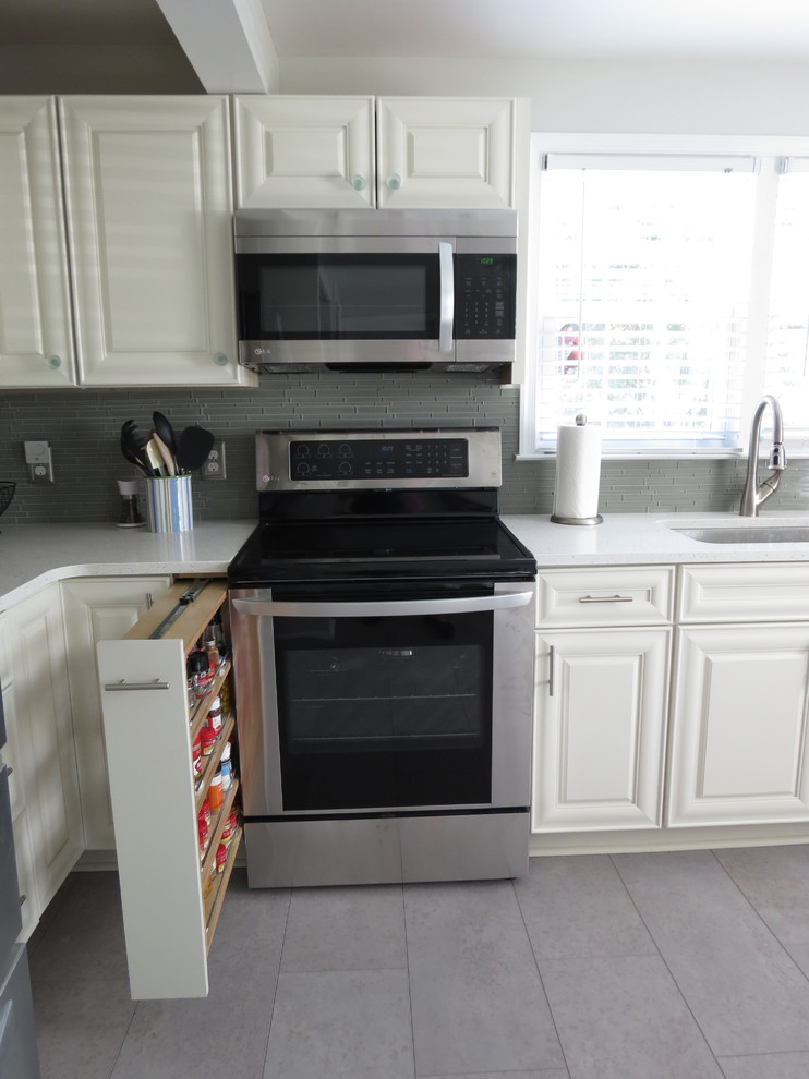 Eat-in kitchen - mid-sized transitional l-shaped purple floor eat-in kitchen idea with an undermount sink, raised-panel cabinets, white cabinets, quartz countertops, gray backsplash, glass tile backsplash, stainless steel appliances, no island and white countertops