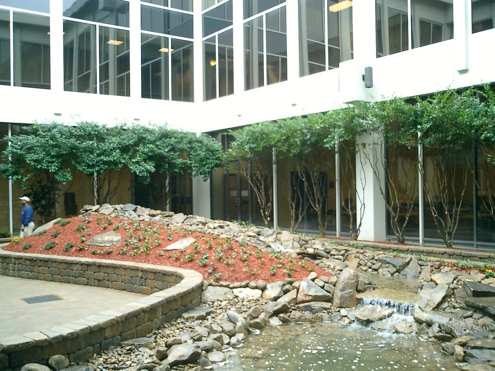 This is an example of a mid-sized contemporary courtyard shaded garden in Atlanta with a water feature and concrete pavers.