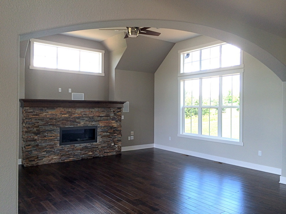Inspiration for a craftsman dark wood floor family room remodel in Milwaukee with beige walls, a standard fireplace and a stone fireplace
