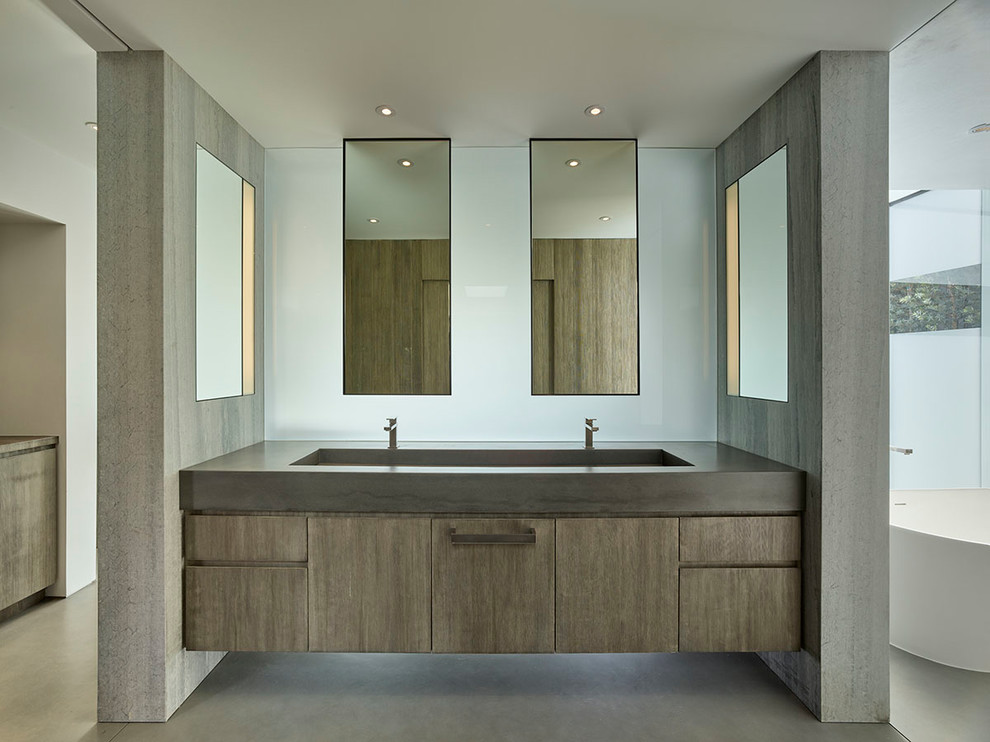 Inspiration for a mid-sized midcentury master bathroom in Los Angeles with glass-front cabinets, light wood cabinets, a freestanding tub, a curbless shower, a one-piece toilet, brown tile, brown walls, concrete floors, an integrated sink, concrete benchtops, green floor, a hinged shower door and grey benchtops.
