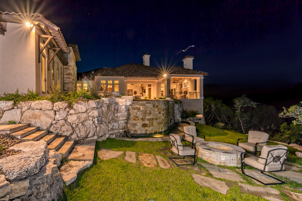 Example of a large mountain style backyard stone infinity pool design in Austin
