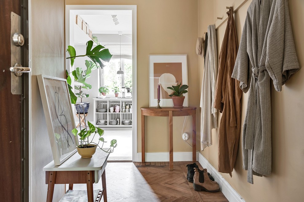 Design ideas for a small scandinavian entryway in Malmo with beige walls, medium hardwood floors and brown floor.