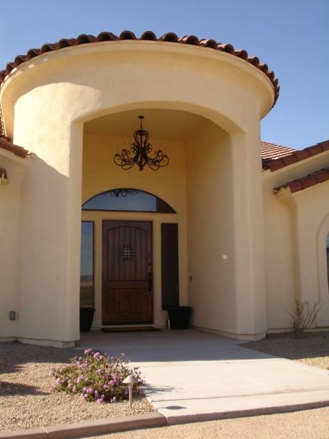 This is an example of a large mediterranean one-storey stucco beige exterior in Phoenix.