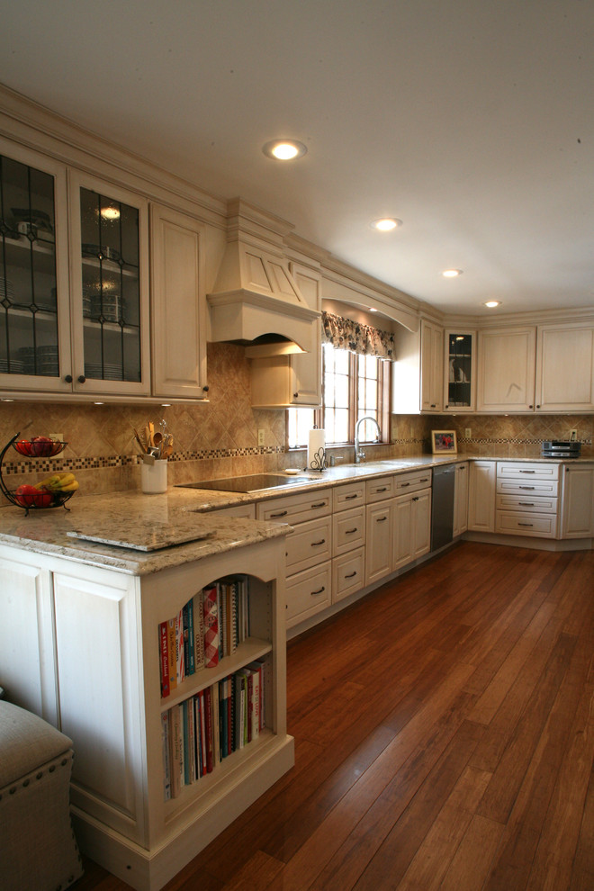 Design ideas for a large traditional galley separate kitchen in Cleveland with an undermount sink, raised-panel cabinets, beige cabinets, quartz benchtops, beige splashback, ceramic splashback, stainless steel appliances and bamboo floors.