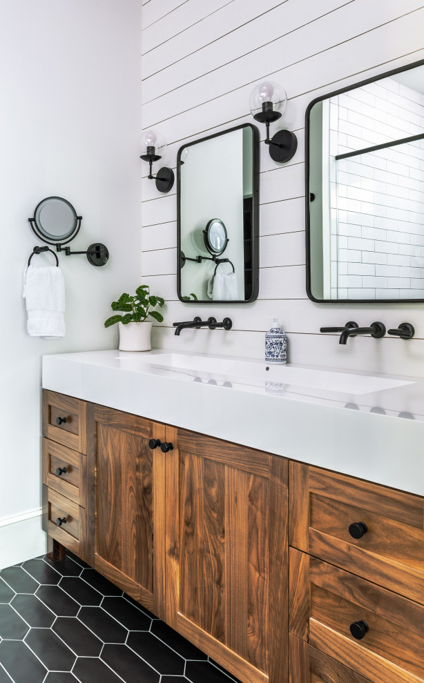 Transitional master bathroom in Atlanta with shaker cabinets, medium wood cabinets, white walls, a trough sink, black floor, white benchtops, a double vanity, a freestanding vanity and planked wall panelling.