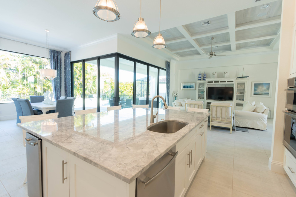 This is an example of a large transitional l-shaped open plan kitchen in Miami with an undermount sink, shaker cabinets, white cabinets, granite benchtops, grey splashback, stone tile splashback, stainless steel appliances, ceramic floors and with island.
