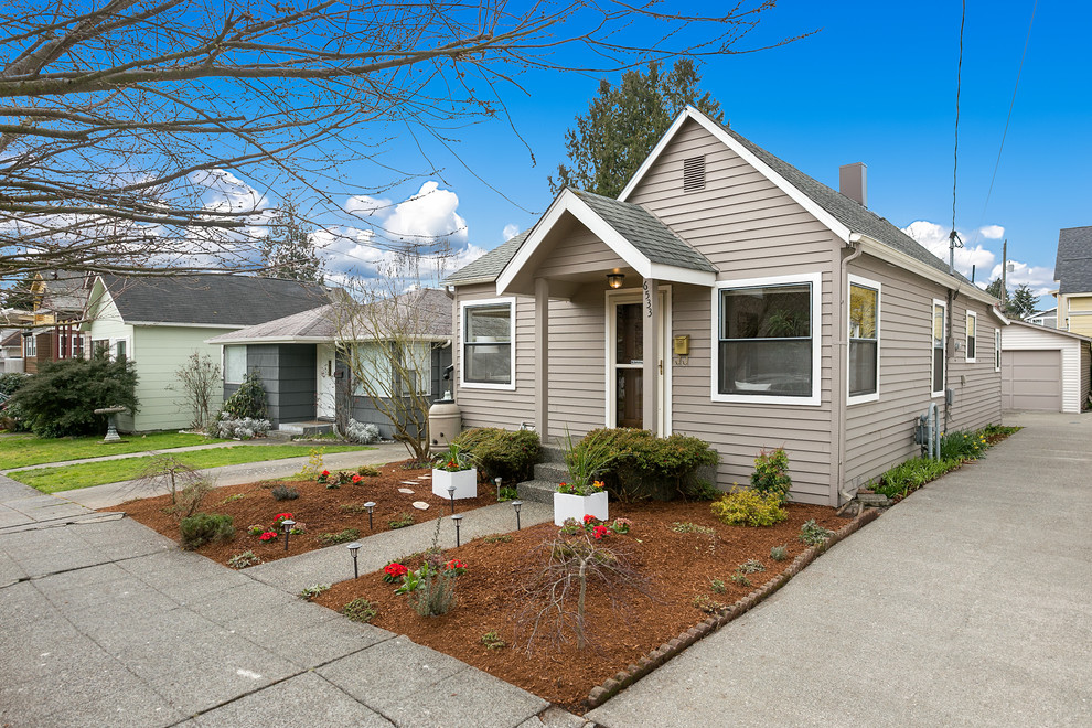 Photo of a small contemporary one-storey grey house exterior in Seattle with wood siding and a shingle roof.