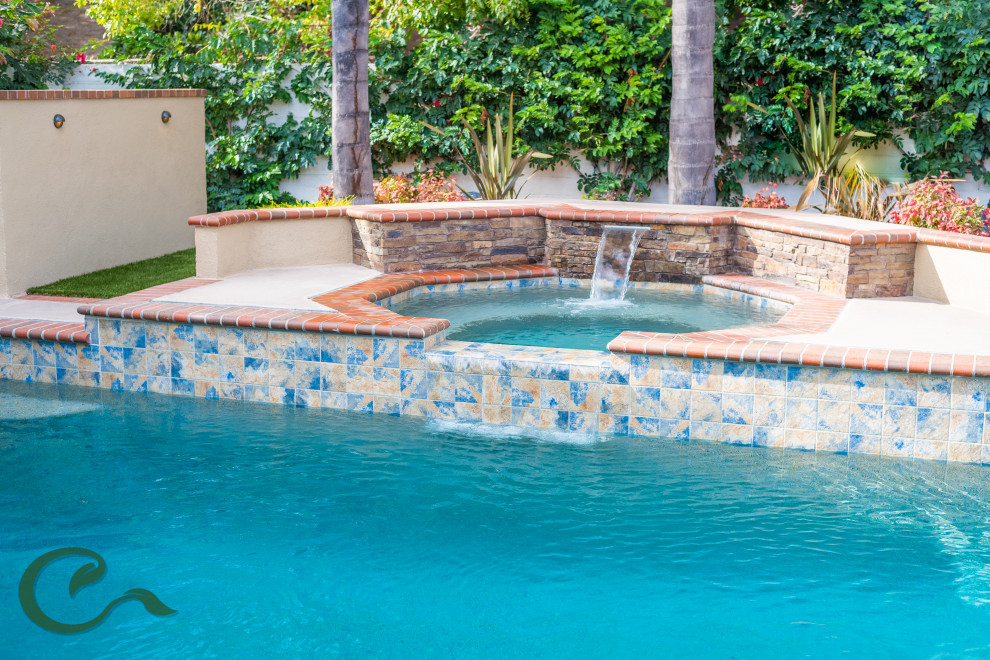 Photo of a mid-sized mediterranean backyard custom-shaped aboveground pool in Orange County with a hot tub and brick pavers.