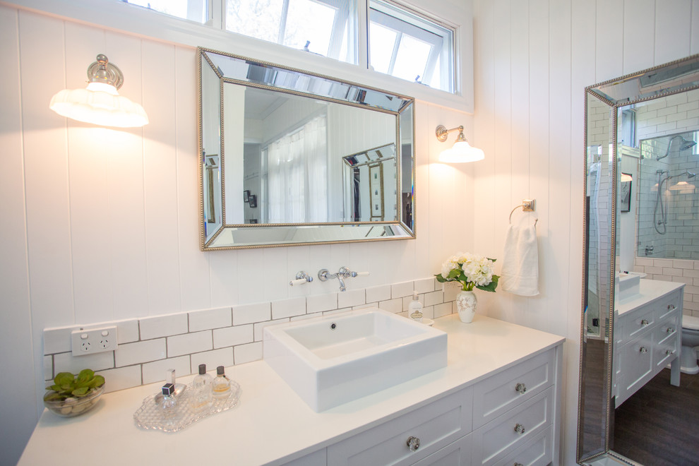 Inspiration for a large traditional master bathroom in Brisbane with furniture-like cabinets, white cabinets, a curbless shower, a one-piece toilet, white tile, subway tile, white walls, concrete floors, a vessel sink and engineered quartz benchtops.