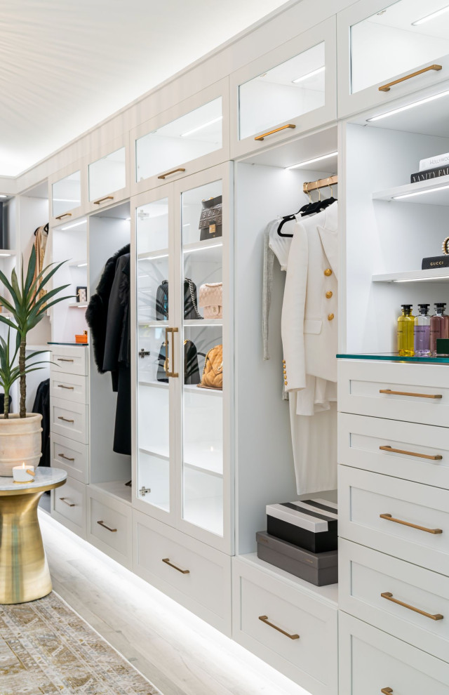 This is an example of a large classic walk-in wardrobe for women in Other with recessed-panel cabinets and white cabinets.