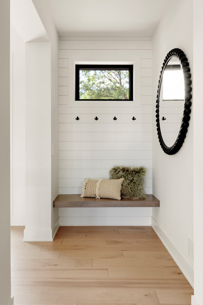 Foyer mit weißer Wandfarbe, hellem Holzboden, Haustür aus Glas, gewölbter Decke und Holzdielenwänden in Minneapolis