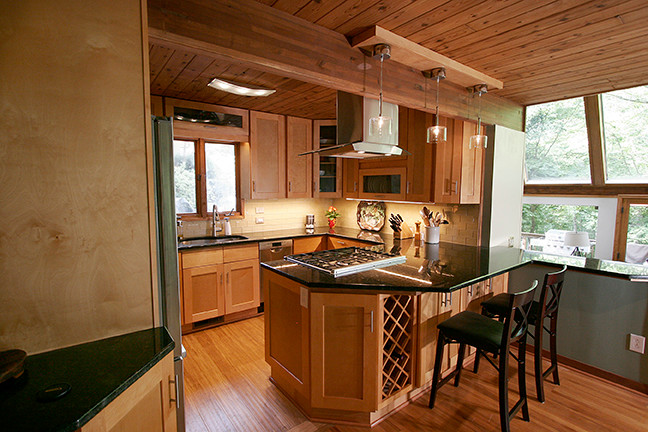 Small transitional l-shaped porcelain tile eat-in kitchen photo with shaker cabinets, light wood cabinets, granite countertops, beige backsplash, glass tile backsplash, stainless steel appliances and a peninsula