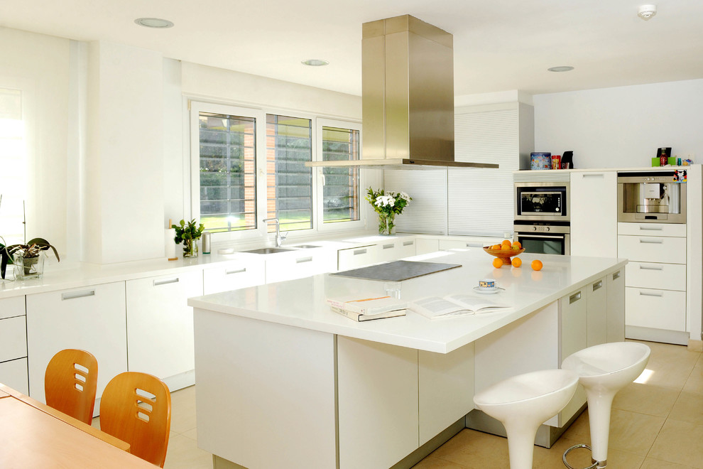 Contemporary l-shaped eat-in kitchen in Madrid with flat-panel cabinets, white cabinets, stainless steel appliances and with island.