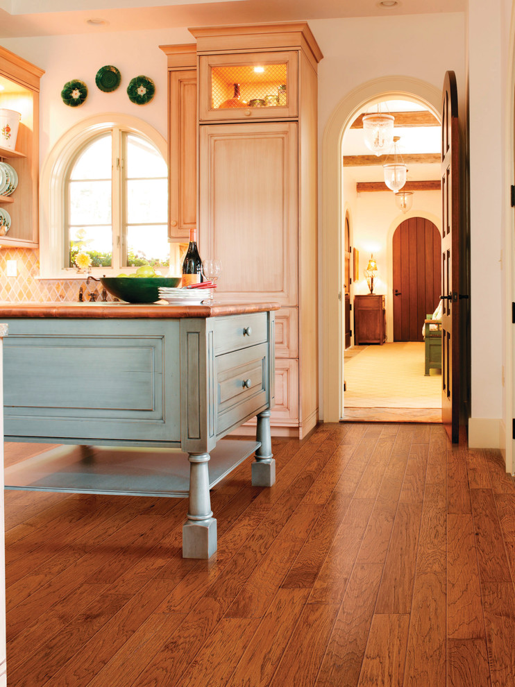 Example of a large transitional l-shaped medium tone wood floor eat-in kitchen design with beaded inset cabinets, distressed cabinets, wood countertops, beige backsplash, stone tile backsplash, paneled appliances and an island