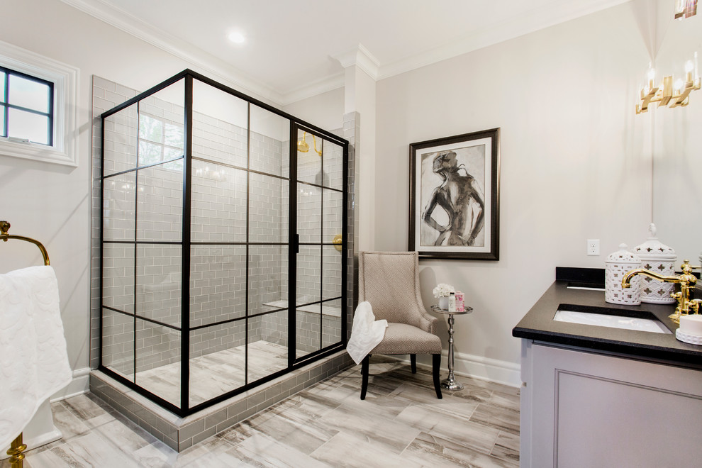 Inspiration for a mid-sized transitional master bathroom in Richmond with a corner shower, gray tile, subway tile, grey walls, an undermount sink, white cabinets and a sliding shower screen.
