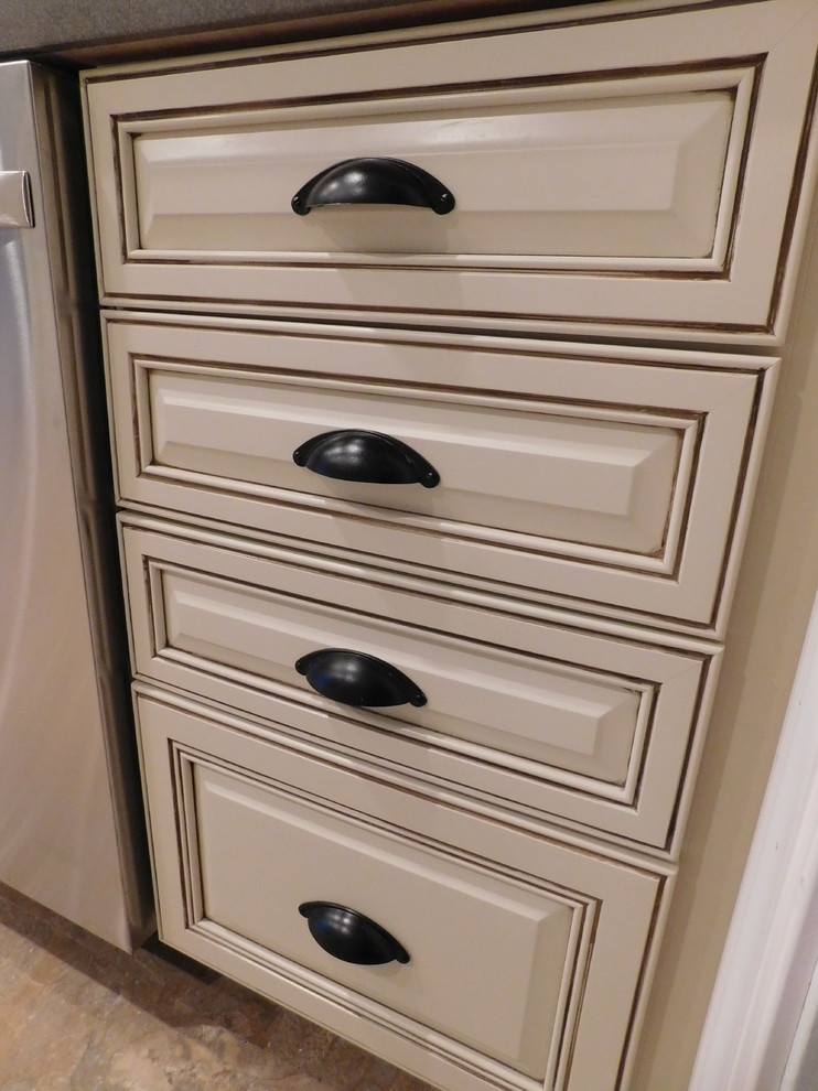 Enclosed kitchen - mid-sized transitional galley vinyl floor enclosed kitchen idea with a farmhouse sink, raised-panel cabinets, beige cabinets, solid surface countertops, multicolored backsplash, stone tile backsplash, stainless steel appliances and no island