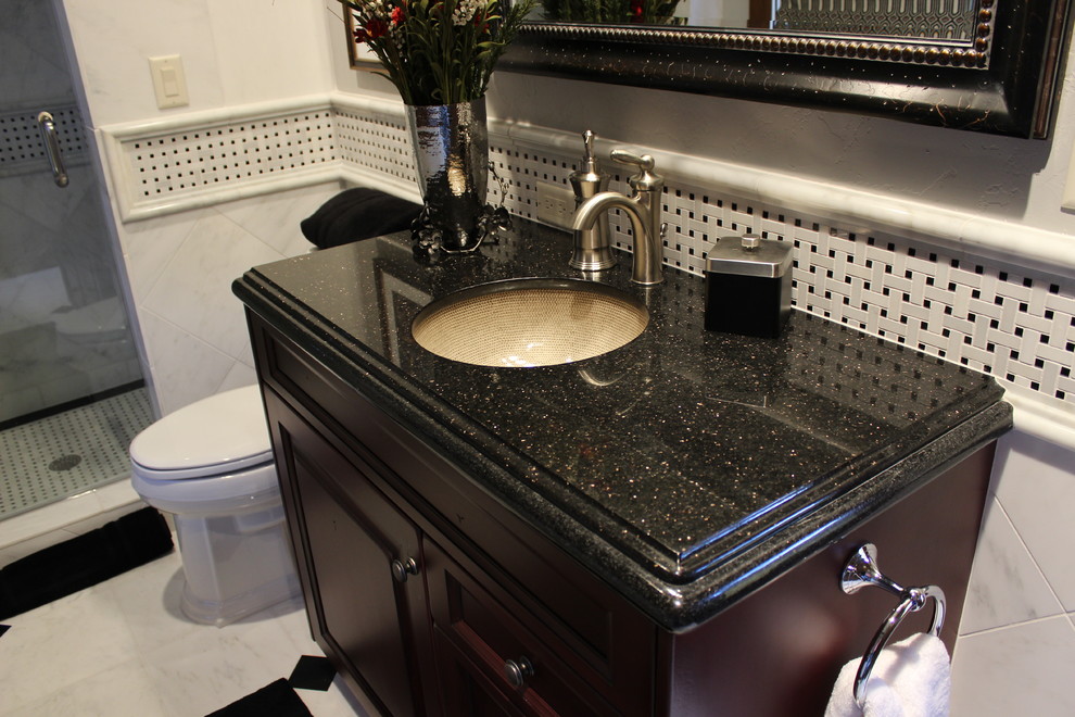 Example of a mid-sized classic 3/4 black and white tile and mosaic tile marble floor alcove shower design in Denver with furniture-like cabinets, dark wood cabinets, an undermount sink, granite countertops, a one-piece toilet and white walls