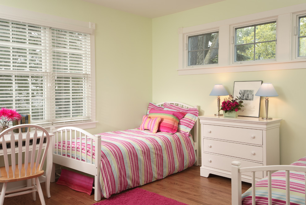 Design ideas for a mid-sized traditional kids' bedroom for kids 4-10 years old and girls in Chicago with green walls and medium hardwood floors.
