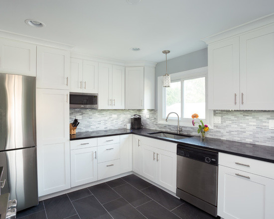 Large transitional l-shaped open plan kitchen in Chicago with an undermount sink, shaker cabinets, white cabinets, granite benchtops, multi-coloured splashback, ceramic splashback, stainless steel appliances, medium hardwood floors and no island.