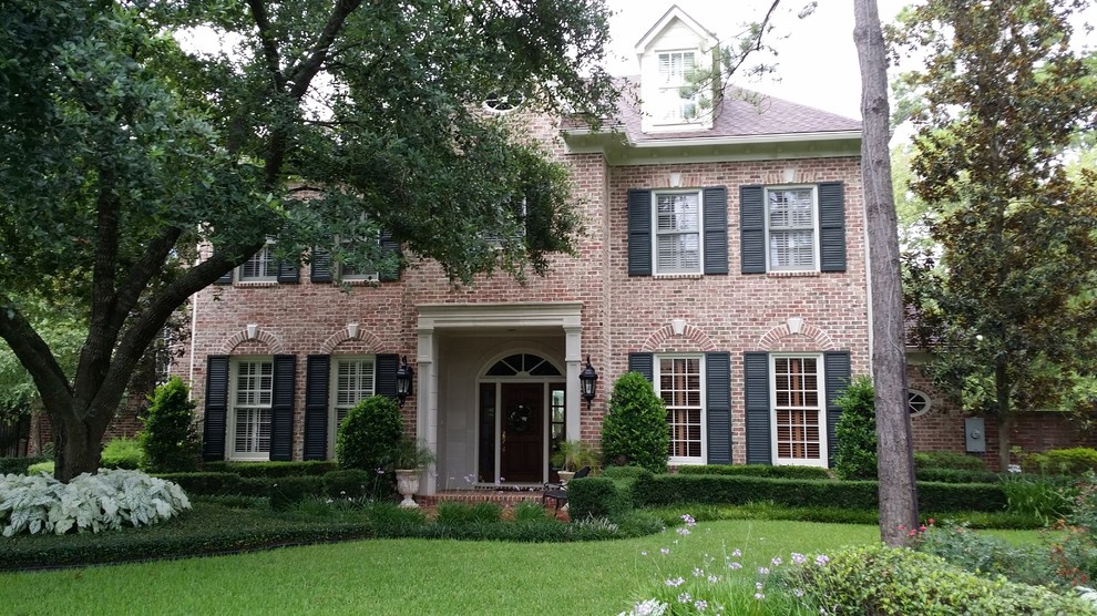 Design ideas for a large traditional three-storey brick red exterior in Houston.
