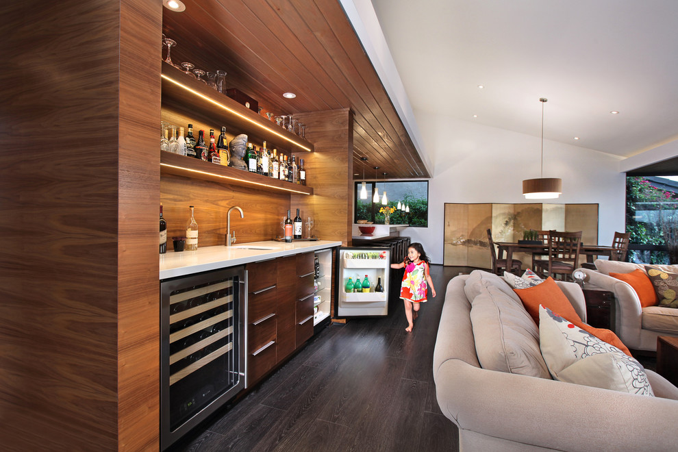 This is an example of a contemporary open concept family room in Orange County with a home bar.
