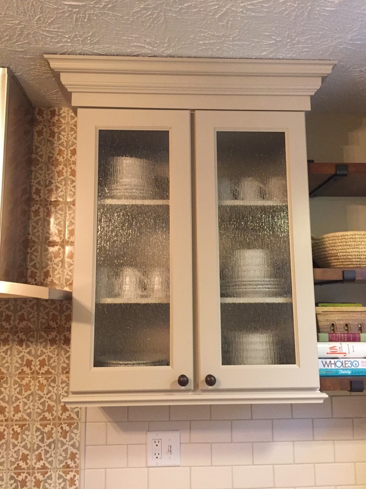 Inspiration for a rustic brown floor kitchen remodel in Cincinnati with a double-bowl sink, raised-panel cabinets, beige cabinets, granite countertops, white backsplash, terra-cotta backsplash and stainless steel appliances