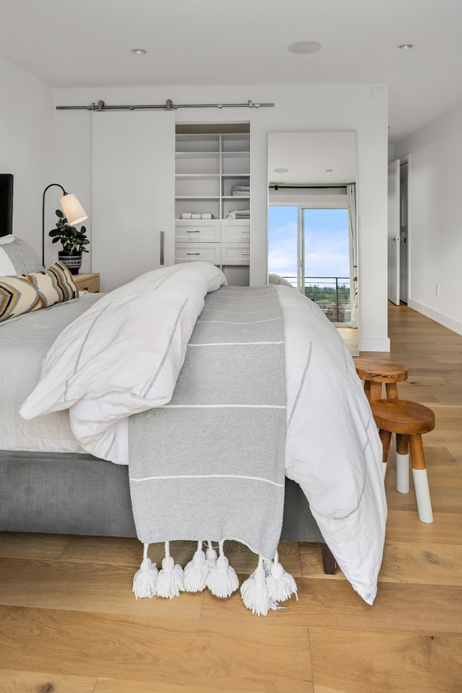 Immagine di una camera degli ospiti moderna di medie dimensioni con pareti bianche, parquet chiaro, nessun camino e pavimento marrone
