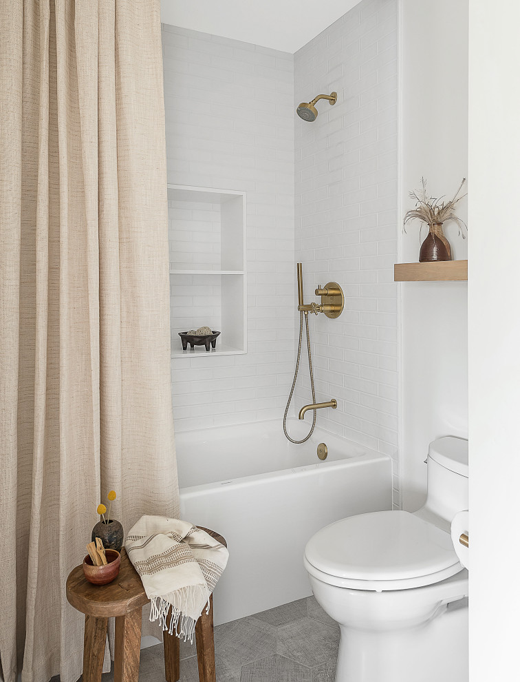 Inspiration for a country bathroom in San Diego with an alcove tub, a shower/bathtub combo, white tile, subway tile, white walls, grey floor and a shower curtain.