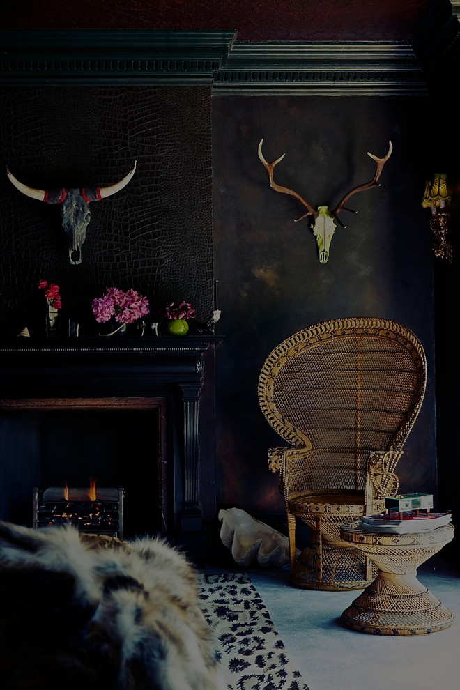 Inspiration for an eclectic formal enclosed living room in Cornwall with black walls, a standard fireplace and a wood fireplace surround.