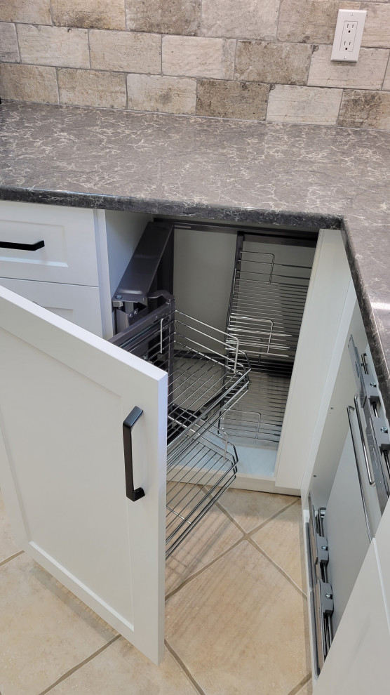 Inspiration for a transitional u-shaped open concept kitchen remodel with an undermount sink, recessed-panel cabinets, white cabinets, multicolored backsplash, stone tile backsplash, stainless steel appliances and a peninsula