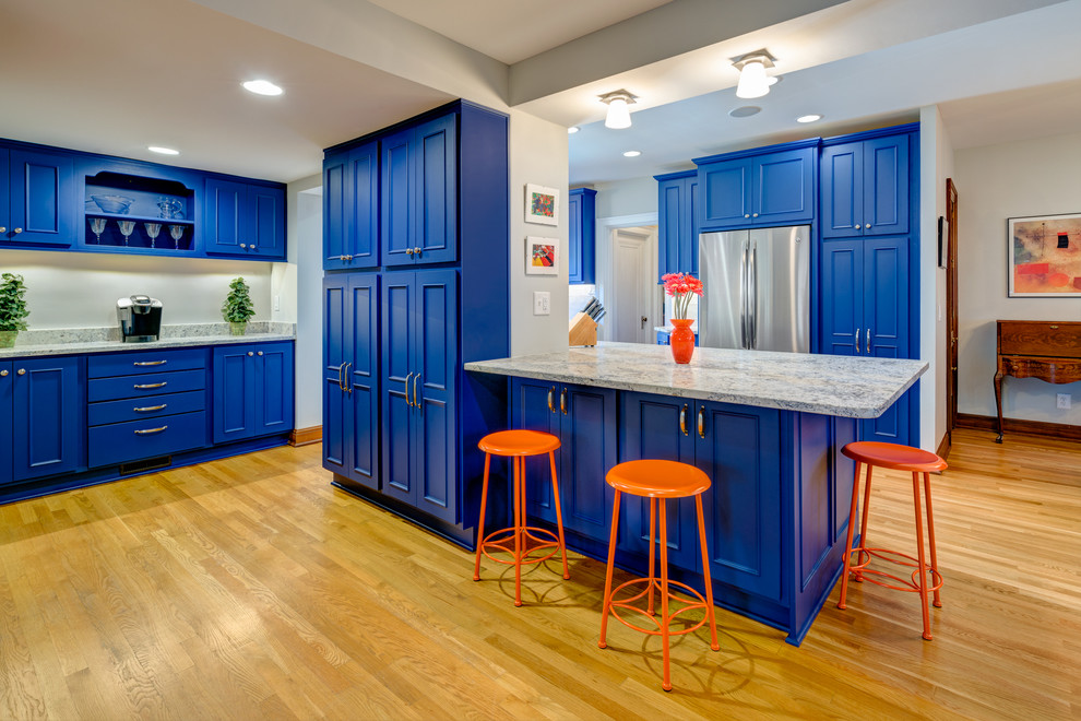 Transitional light wood floor kitchen photo in Columbus with an undermount sink, recessed-panel cabinets, blue cabinets, marble countertops, white backsplash and stainless steel appliances