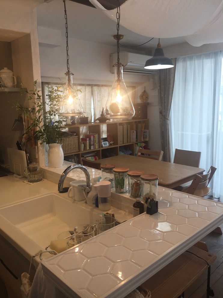 Photo of a small traditional single-wall open plan kitchen in Fukuoka with a single-bowl sink, grey cabinets, solid surface benchtops, porcelain splashback, stainless steel appliances, travertine floors, multiple islands, beige floor and white benchtop.
