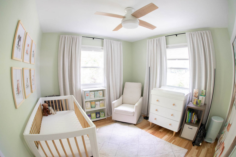 Foto di una piccola cameretta per neonati neutra minimal con pareti verdi e parquet chiaro