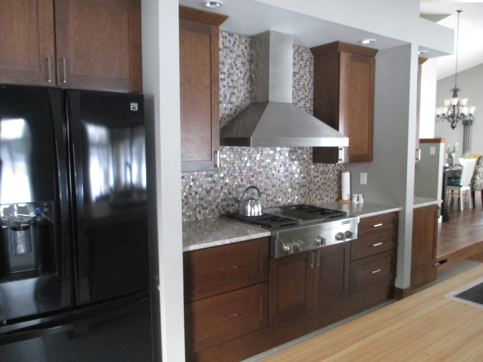Inspiration for a mid-sized transitional galley ceramic tile eat-in kitchen remodel with a drop-in sink, shaker cabinets, dark wood cabinets, quartz countertops, stainless steel appliances, an island, metallic backsplash and mosaic tile backsplash