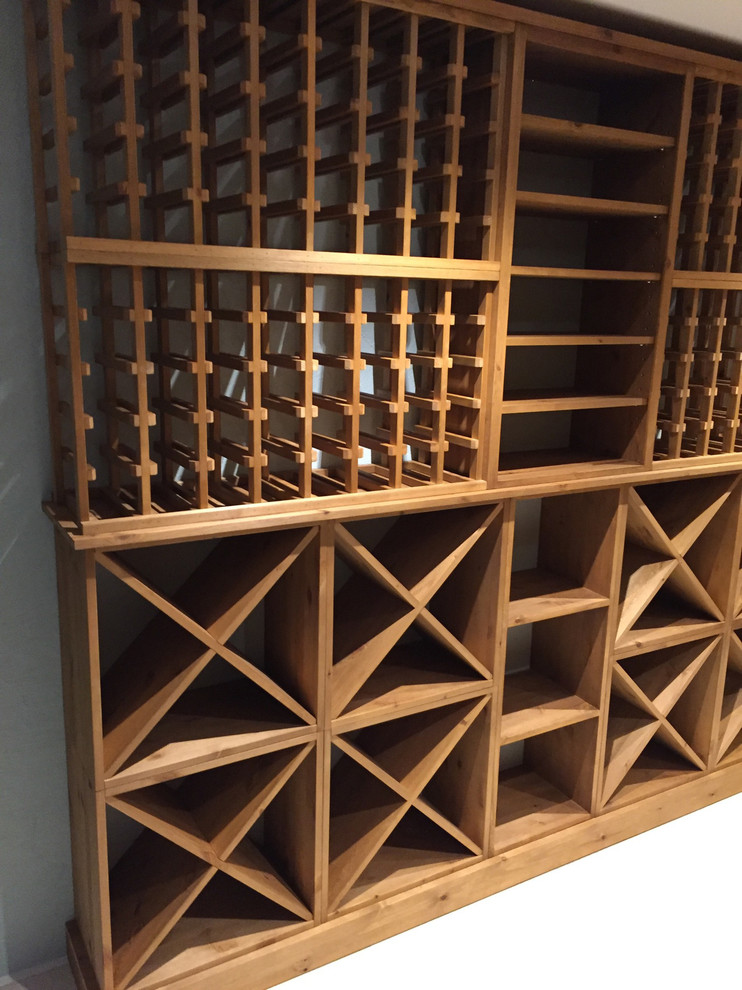 This is an example of a large contemporary wine cellar in Sussex with storage racks, concrete floors and grey floor.