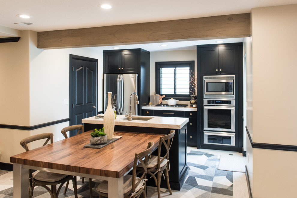 Photo of a transitional l-shaped eat-in kitchen in Salt Lake City with recessed-panel cabinets, black cabinets, wood benchtops and with island.