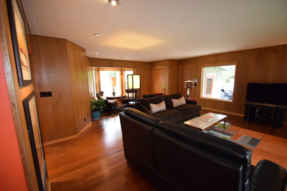 Photo of a large midcentury enclosed family room in Portland with brown walls, bamboo floors, a wood stove, a stone fireplace surround and brown floor.