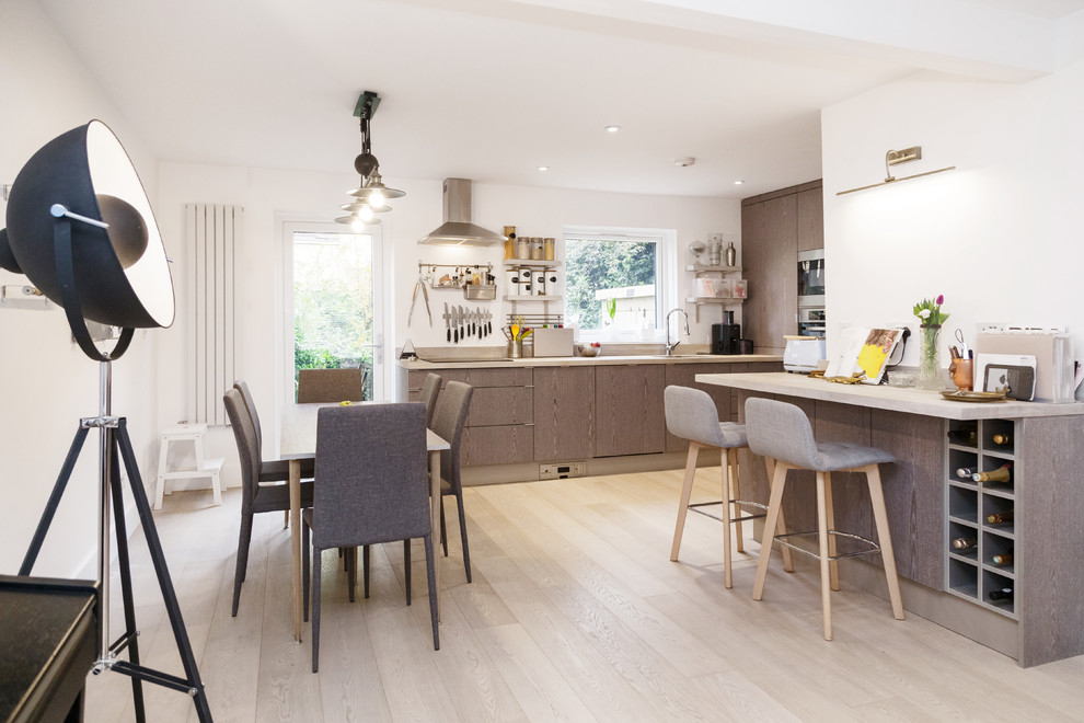Inspiration for a mid-sized contemporary u-shaped open plan kitchen in London with an undermount sink, flat-panel cabinets, grey cabinets, wood benchtops, white splashback, window splashback, panelled appliances, light hardwood floors, a peninsula and white floor.