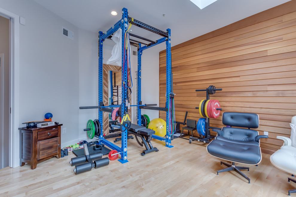 Inspiration for a small modern home weight room in DC Metro with white walls, light hardwood floors and beige floor.
