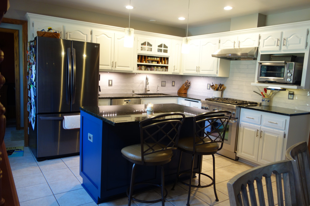 Example of a transitional kitchen design in Milwaukee with granite countertops, gray backsplash, ceramic backsplash and an island