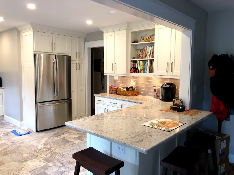 This is an example of a mid-sized transitional u-shaped eat-in kitchen in Baltimore with an undermount sink, recessed-panel cabinets, white cabinets, quartz benchtops, grey splashback, ceramic splashback, stainless steel appliances, travertine floors, a peninsula, multi-coloured floor and multi-coloured benchtop.
