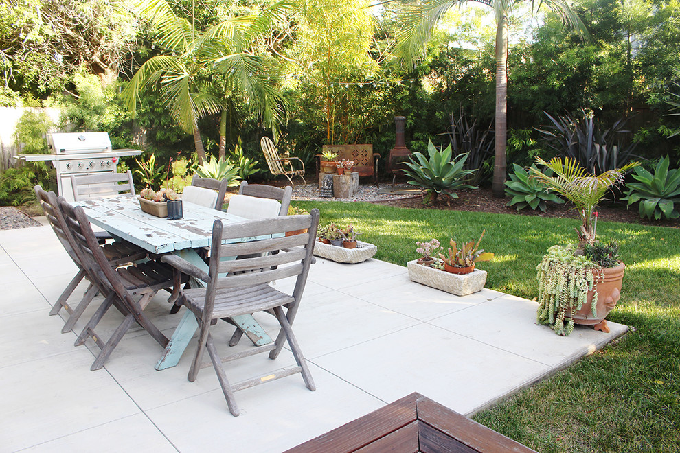 This is an example of a mid-sized tropical front yard full sun xeriscape in Orange County with a garden path and concrete pavers.
