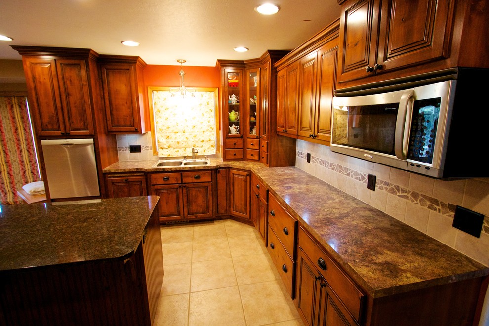Inspiration for a large u-shaped open concept kitchen remodel with a drop-in sink, raised-panel cabinets, medium tone wood cabinets, beige backsplash, ceramic backsplash, stainless steel appliances and an island
