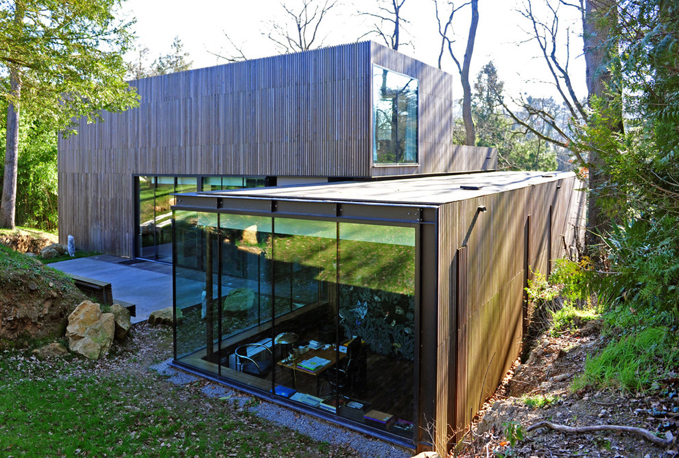 Photo of a mid-sized contemporary two-storey brown exterior in Nantes with wood siding and a flat roof.