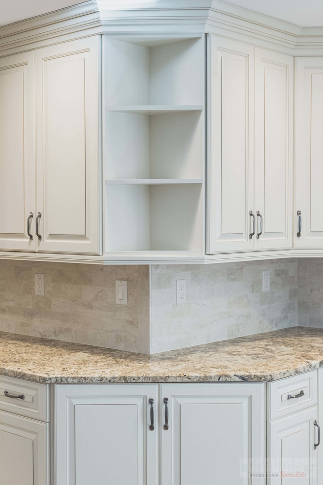 This is an example of a mid-sized galley eat-in kitchen in New York with an undermount sink, raised-panel cabinets, white cabinets, granite benchtops, beige splashback, stainless steel appliances, plywood floors, with island and beige floor.