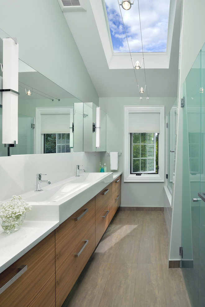 Photo of a mid-sized contemporary kids bathroom in Toronto with a trough sink, flat-panel cabinets, medium wood cabinets, engineered quartz benchtops, an alcove tub, a shower/bathtub combo, green walls and porcelain floors.