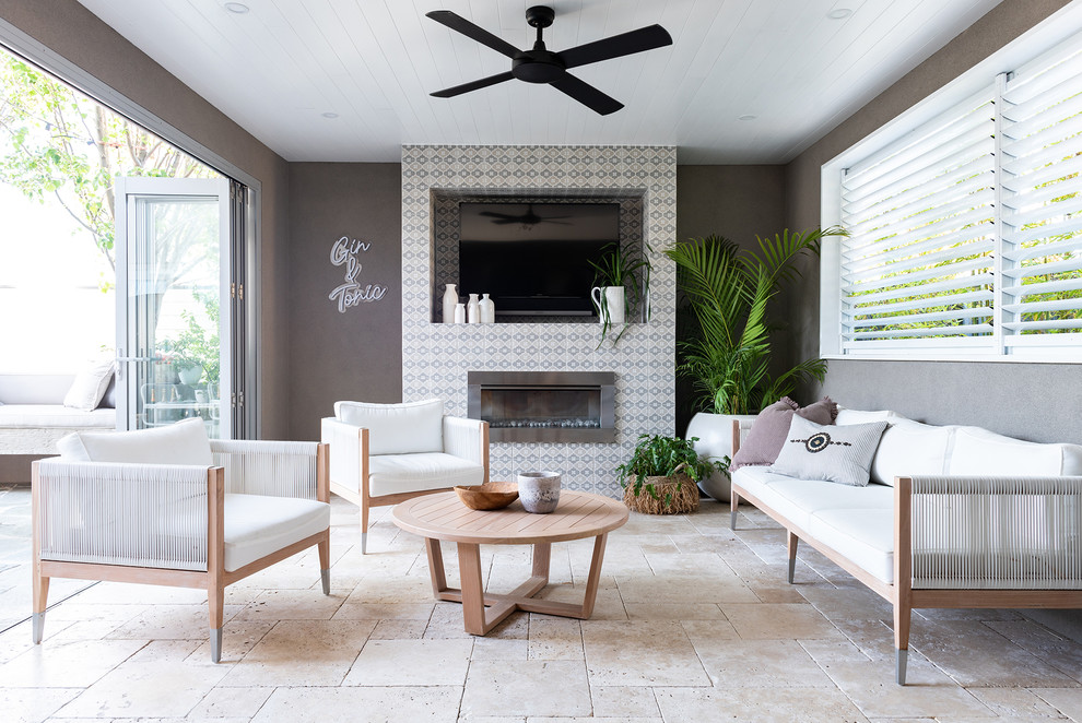Mid-sized beach style backyard patio in Perth with natural stone pavers and a roof extension.