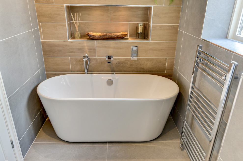 Пример оригинального дизайна: большая главная, серо-белая ванная комната: освещение в стиле модернизм с плоскими фасадами, серыми фасадами, отдельно стоящей ванной, открытым душем, унитазом-моноблоком, серой плиткой, керамической плиткой, серыми стенами, полом из керамической плитки, накладной раковиной, стеклянной столешницей, серым полом, открытым душем, белой столешницей, тумбой под одну раковину и подвесной тумбой