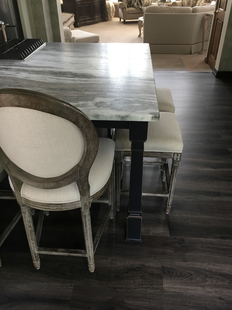 Eat-in kitchen - large transitional u-shaped laminate floor and gray floor eat-in kitchen idea with an undermount sink, recessed-panel cabinets, white cabinets, granite countertops, white backsplash, ceramic backsplash, stainless steel appliances, an island and black countertops